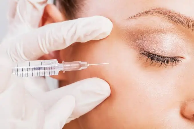 Provider injecting Botox near the crow's feet area during a treatment at the laser cafe