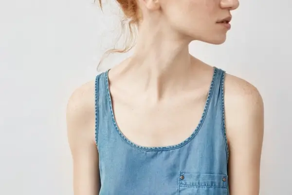 front view of woman with neck bands wearing blue vest