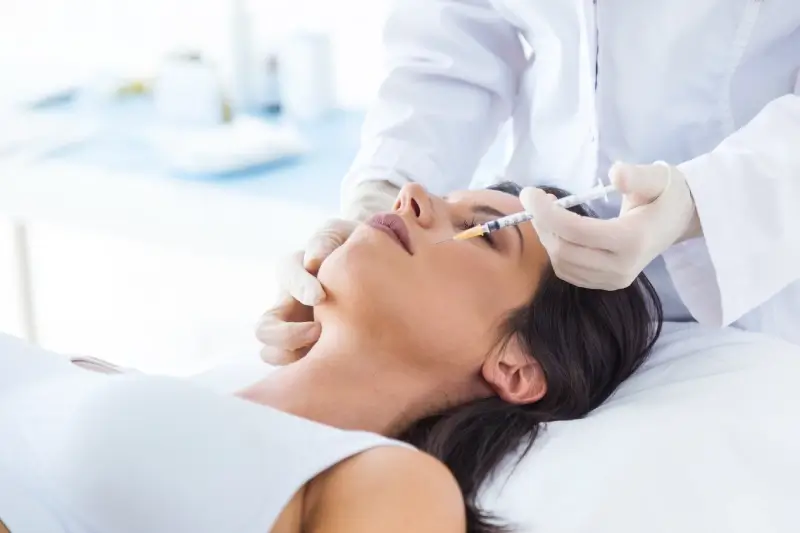 women getting botox on her face