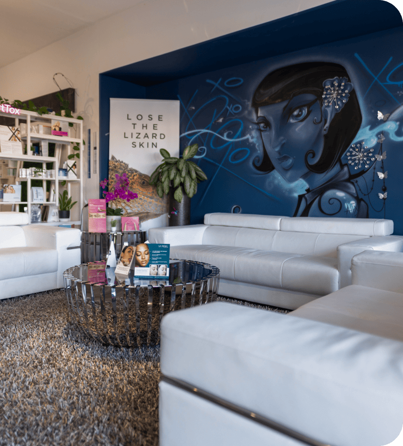 a living room with white sofa and painting in wall