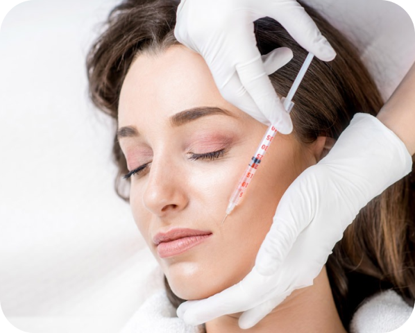 a doctor with white gloves injecting dermal filler at cheek area of a women at the laser cafe