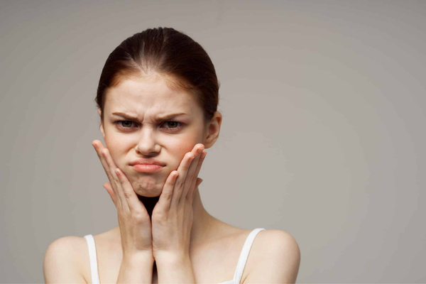 women touching her cheeks with visible textured orange peel chin